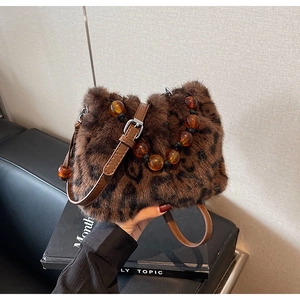 Detailed shot of leopard print faux fur bucket bag with amber beads and leather strap