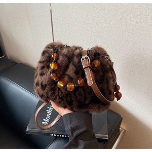 Detailed view of leopard print bucket bag featuring amber bead handle and soft faux fur texture