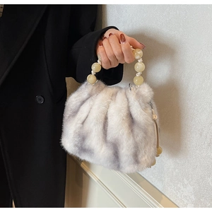 Detail of grey faux fur bucket bag with amber bead handle and soft pleated texture