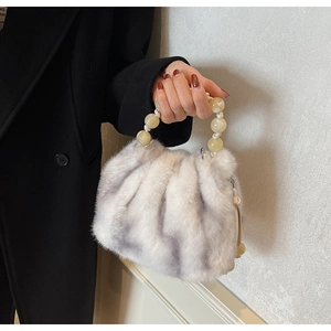 Detailed macro view of plush faux fur texture and yellow beaded handle of bucket bag