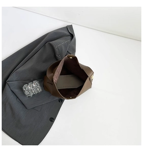 Internal view of the large brown bucket bag showing the golden magnetic closure and lining