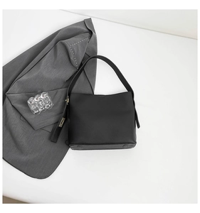 Top-down view of a chic black leather bucket bag with a wide strap and gold hardware accents
