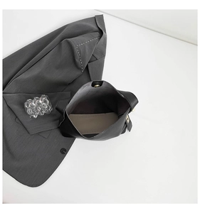 Internal view of black leather bucket bag with khaki lining and golden snap button closure