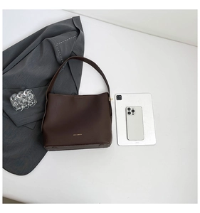 Deep brown minimalist faux leather tote bag showing large capacity and textured matte finish