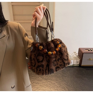 Detail of faux mink leopard print bucket bag with amber beaded chain and leather handles