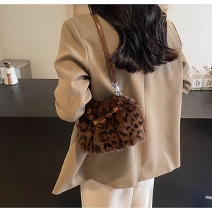 Close-up of leopard print faux fur bucket bag with amber beaded handle and leather strap
