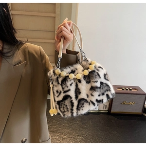 Detail of leopard print faux fur bucket bag with beaded handle and elegant tassel accent