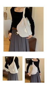 Detail view of beige corduroy sling bag featuring adjustable strap and metal D-ring hardware