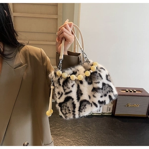 Detail of faux mink leopard bucket bag with yellow beaded handle and plush texture