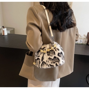 Detailed close-up of leopard print faux fur bucket bag with beaded handle and leather strap
