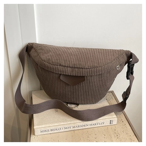 Detailed close-up of brown corduroy waist bag with leather accent and wide strap