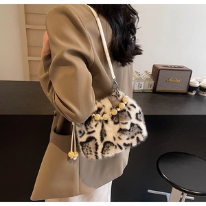 Detail of leopard print faux fur bucket bag with white bead handle and crossbody strap