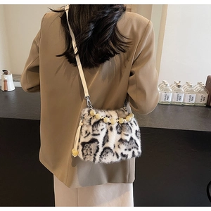 Detail of leopard print faux fur bucket bag with beaded handle and leather strap