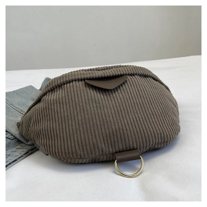 Detail view of corduroy crossbody bag with brown leather accents and gold hardware