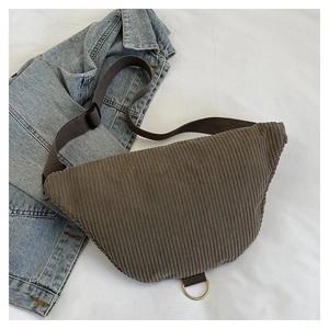 Close-up of brown corduroy waist bag showing texture and golden D-ring detail