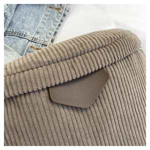 Close-up of coffee brown corduroy waist bag showing ribbed texture and leather detail