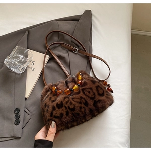 Detail of leopard print faux fur bucket bag with amber beads and leather strap