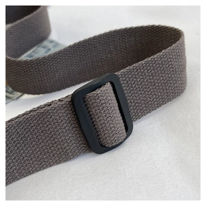 Detailed macro view of the dark brown corduroy strap with a black rectangular buckle
