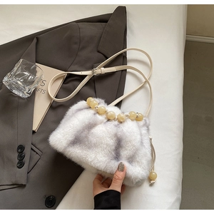 Close-up of faux fur bucket bag featuring translucent yellow beaded handle and drawstring