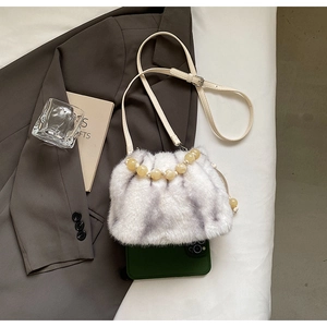 Detail of faux fur bucket bag showing interior capacity with a smartphone inside