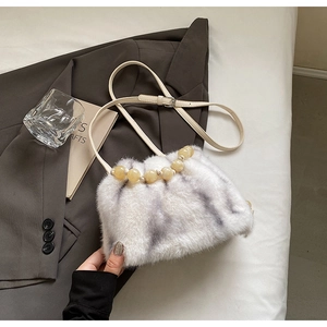 Detail of faux mink fur crossbody bucket bag with grey striped texture and beaded handle