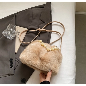 Close-up of faux mink fur bucket bag with beige pearl bead handle and leather strap