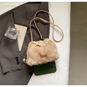 Detail view of plush mini shoulder bag with large pearl trim and thin brown strap