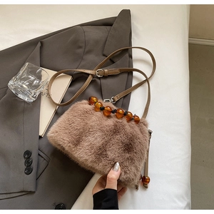 Detail of faux mink bucket bag featuring amber acrylic beads and plush brown texture