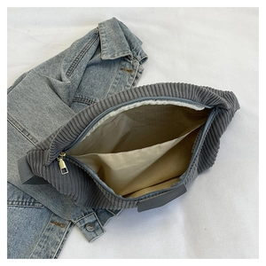 Detail view of the gray corduroy crossbody bag showing the inner lining and side pocket