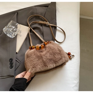 Detail of faux mink fur bucket bag featuring amber beads and a leather strap