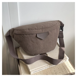Macro view of brown corduroy crossbody bag texture and leather logo patch detail