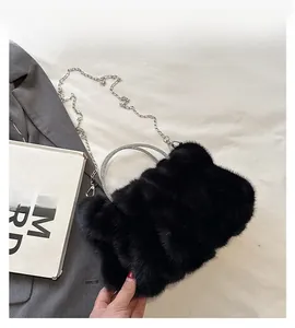 Détail d'un sac à main en peluche noire avec poignée en strass et bandoulière en chaîne