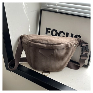 Macro shot of brown corduroy waist bag showing ribbed fabric texture and metal ring detail