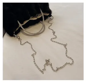 Détail du sac en peluche avec poignée en strass étincelants et bandoulière chaîne en métal