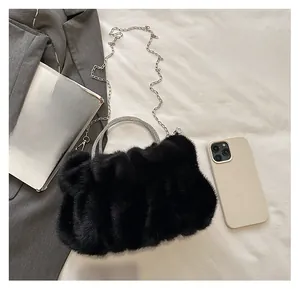 Détail d'un sac nuage en fausse fourrure noire avec poignée en strass et chaîne fine