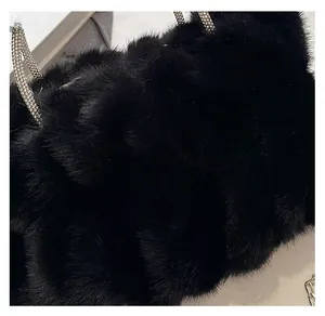 Détail du sac à main en fausse fourrure noire avec poignées ornées de strass