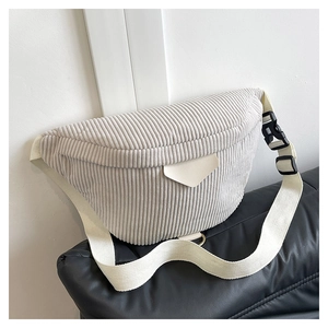 Detail of light grey corduroy crossbody bag with adjustable strap and textured fabric