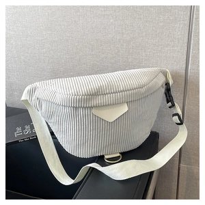 Detail shot of light grey corduroy texture and adjustable strap buckle on a chest bag