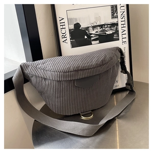 Detail view of a gray corduroy crescent belt bag showing soft ribbed texture and metal ring