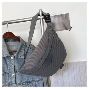Close-up of grey corduroy crescent chest bag with metal ring and canvas strap