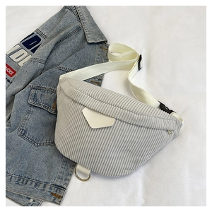 Detailed close-up of light gray corduroy waist bag with metal ring and white fabric strap