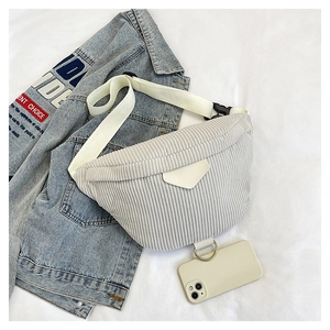 Macro detail of grey corduroy crossbody bag with adjustable strap and metal hanging ring
