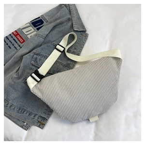 Detail view of light grey corduroy crossbody bag with adjustable wide strap and texture