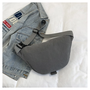 Detail of gray corduroy crescent bag showing fine ribbed texture and adjustable strap