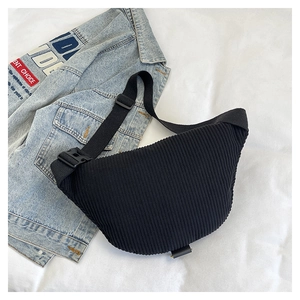 Detail of black corduroy crescent bag with textured stripes and adjustable strap