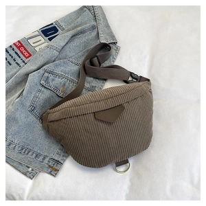 Detail of dark brown corduroy waist bag showing vertical texture and adjustable strap