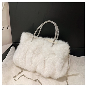Détail du sac à main en fausse fourrure blanche avec poignées en strass et chaîne argent