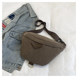 Close-up of brown corduroy chest bag featuring vertical texture and metal D-ring detail