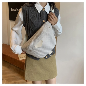 Detailed texture of white corduroy crossbody bag with leather flap and canvas strap