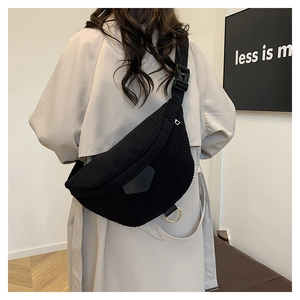 Detail of black corduroy belt bag showing vertical ribbed texture and adjustable strap